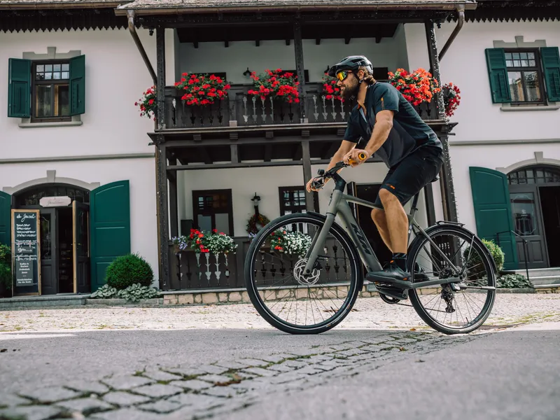 Radfahrer vor österreichischem Haus mit Geranien